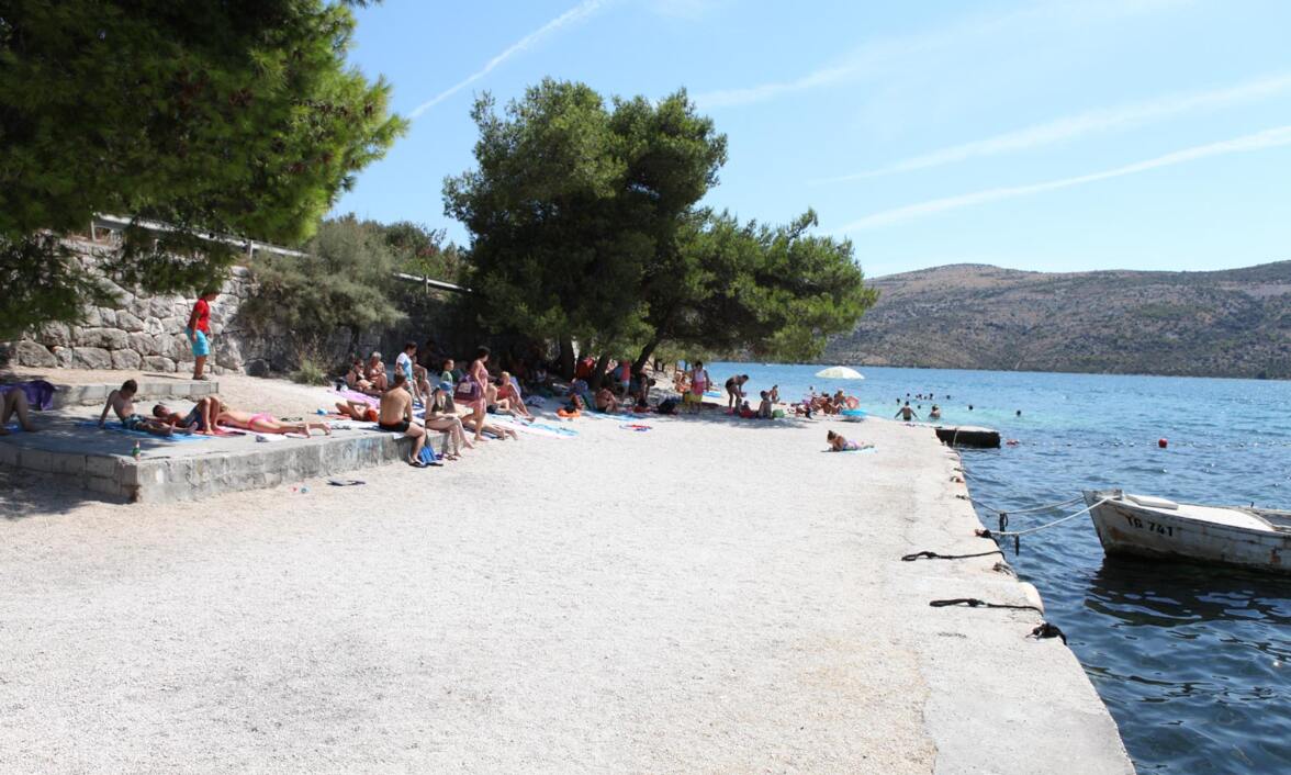 Betonska plaža Poljica, kupači u hladu drveća